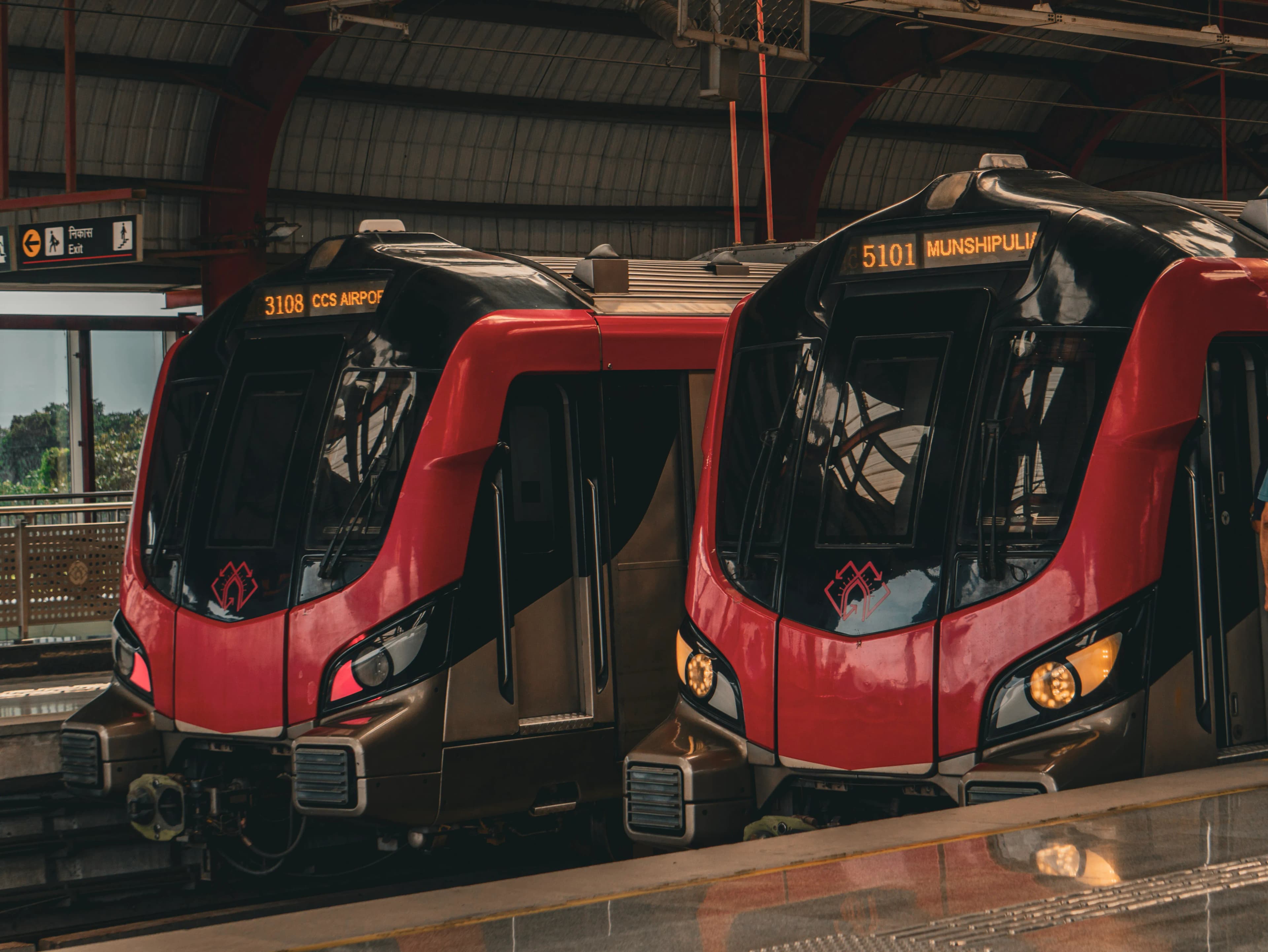 Two red metro trains waiting at a modern station platform.